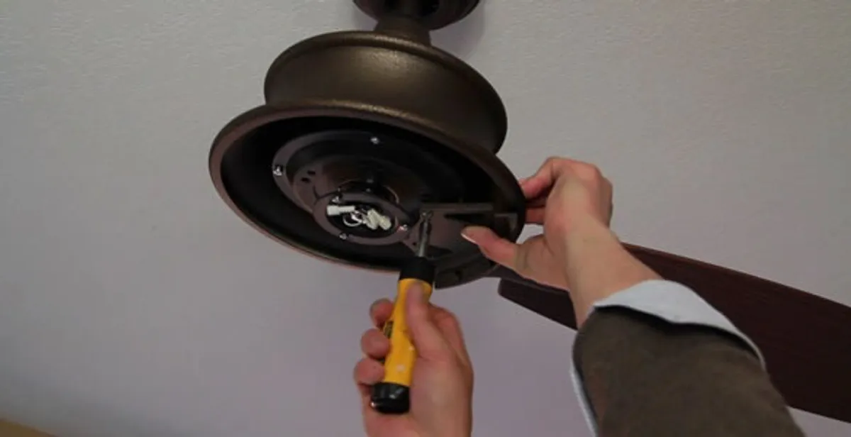 Electrician installing ceiling fan mounting bracket and fixture in Saint Petersburg, FL
