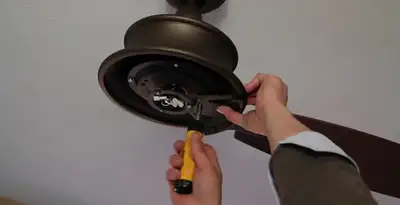 Electrician installing ceiling fan mounting bracket and fixture in Saint Petersburg, FL