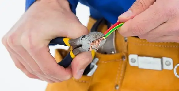 licensed electrician securing electrical wiring with professional tools during service work in Saint Petersburg, FL