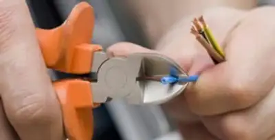 licensed electrician performing precise wire cutting and preparation during electrical service in Saint Petersburg, FL