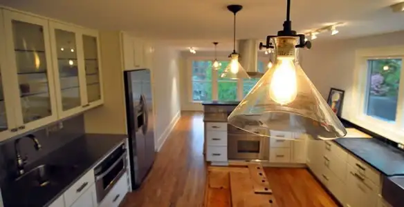 Residential electrician installing modern indoor light fixture in a home in Saint Petersburg, FL