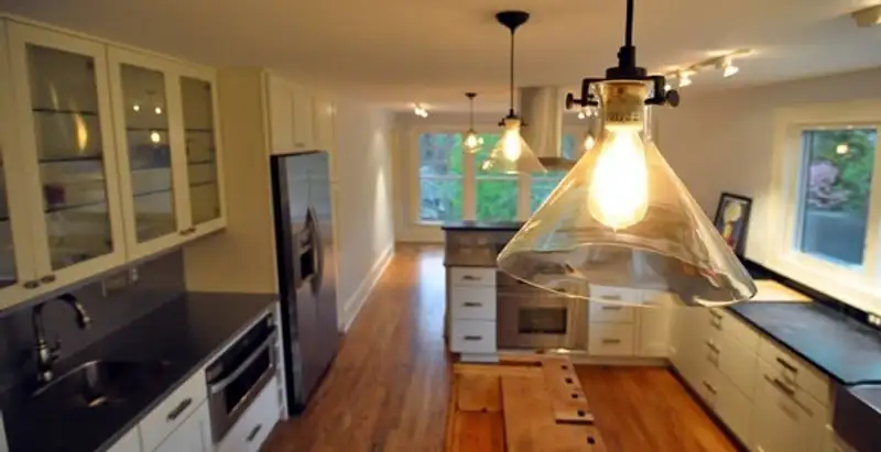 Residential electrician installing modern indoor light fixture in a home in Saint Petersburg, FL