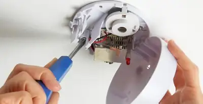 Certified technician wiring smoke detector during installation in Saint Petersburg, FL